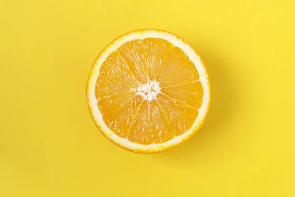 Rebanada de naranja, sobre fondo amarillo . — Foto de Stock