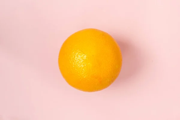 Isolated orange orange against a pink background — Stock Photo, Image