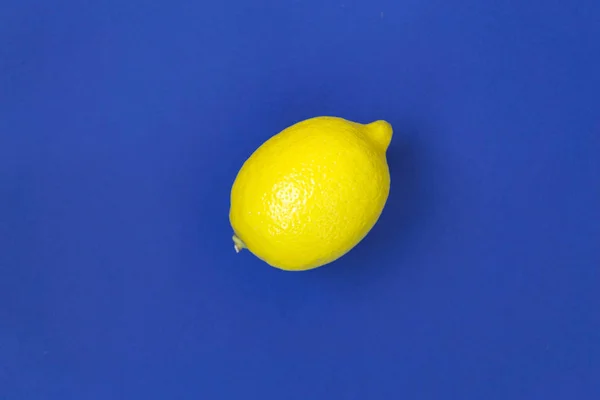 Ripe yellow lemon on blue background — Stock Photo, Image