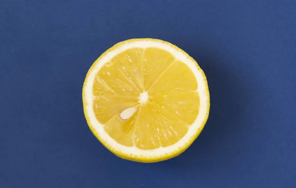 Fresh lemon slice close up on bright blue background. Flat lay. — Stock Photo, Image