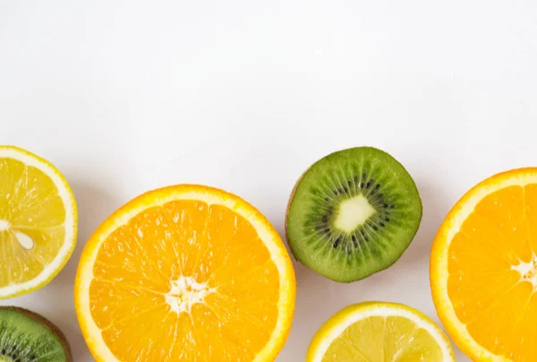 Frutas frescas de colores sobre fondo blanco. Naranja, mandarina, kiwi, limón. Fondo de fruta. Concepto de comida de verano . — Foto de Stock