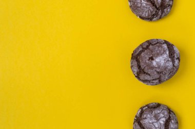 Düz çikolata mermer kurabiye sarı bir arka plan üzerinde yatıyordu. Çikolatalı kurabiye atış.