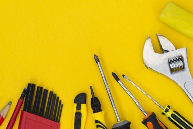 Diy alet seti. Araçlar sarı bir arka plan üzerinde yatıyor. Metin için bir yer var.