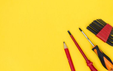 Diy alet seti. Araçlar sarı bir arka plan üzerinde yatıyor. Metin için bir yer var.