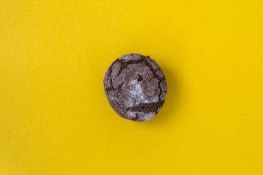 Düz çikolata mermer kurabiye sarı bir arka plan üzerinde yatıyordu. Çikolatalı kurabiye atış.