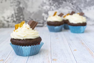 Vanilya tereyağı frosting ve altın kırıntıları, çikolata ve limon ile Çikolata cupcakes. Metin için bir not var.