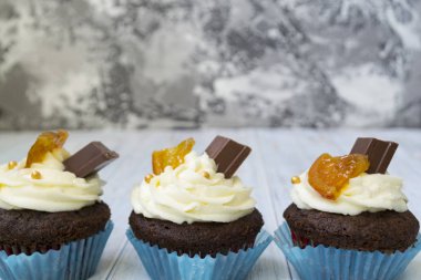 Vanilya tereyağı frosting ve altın kırıntıları, çikolata ve limon ile Çikolata cupcakes. Metin için bir not var.