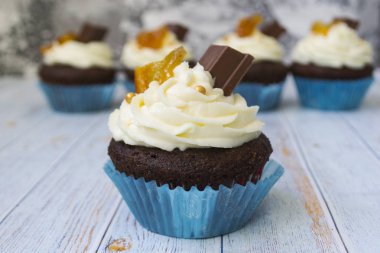 Vanilya tereyağı frosting ve altın kırıntıları, çikolata ve limon ile Çikolata cupcakes. Metin için bir not var.