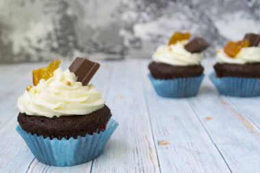 Vanilya tereyağı frosting ve altın kırıntıları, çikolata ve limon ile Çikolata cupcakes. Metin için bir not var.