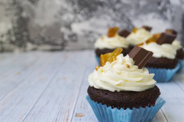 Vanilya tereyağı frosting ve altın kırıntıları, çikolata ve limon ile Çikolata cupcakes. Metin için bir not var.