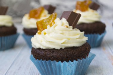 Vanilya tereyağı frosting ve altın kırıntıları, çikolata ve limon ile Çikolata cupcakes. Metin için bir not var.