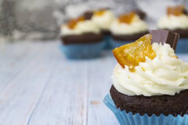 Vanilya tereyağı frosting ve altın kırıntıları, çikolata ve limon ile Çikolata cupcakes. Metin için bir not var.
