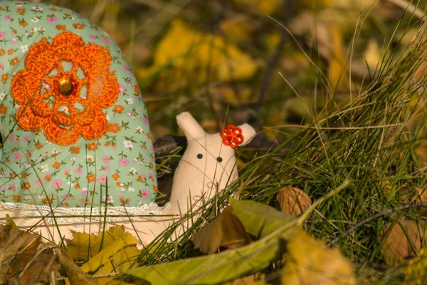 Textile toy snail crawling on the yellow foliage and grass. Close-up. Blurred background. — Stock Photo, Image