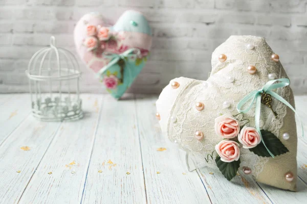 Dos corazones textiles con un romántico color de flores sobre un simple fondo de madera clara. enfoque selectivo. Hay un lugar para el texto . — Foto de Stock