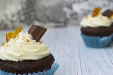 Vanilya tereyağı frosting ve altın kırıntıları, çikolata ve limon ile Çikolata cupcakes. Metin için bir not var.