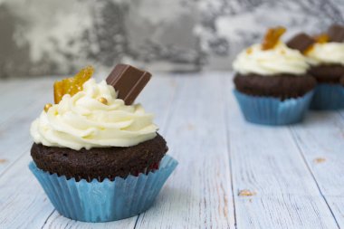 Vanilya tereyağı frosting ve altın kırıntıları, çikolata ve limon ile Çikolata cupcakes. Metin için bir not var.