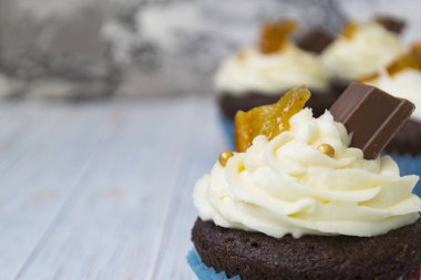 Vanilya tereyağı frosting ve altın kırıntıları, çikolata ve limon ile Çikolata cupcakes. Metin için bir not var.