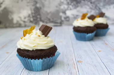 Vanilya tereyağı frosting ve altın kırıntıları, çikolata ve limon ile Çikolata cupcakes. Metin için bir not var.