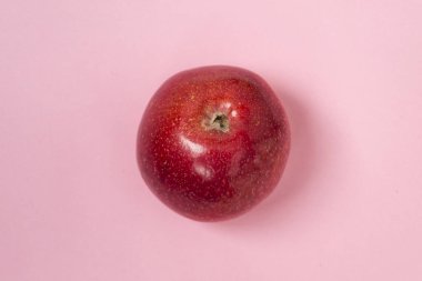 Düz pembe bir arka plan üzerinde taze kırmızı elma. Sağlıklı gıda kavramı.