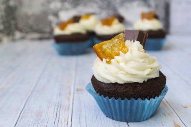 Vanilya tereyağı frosting ve altın kırıntıları, çikolata ve limon ile Çikolata cupcakes. Metin için bir not var.