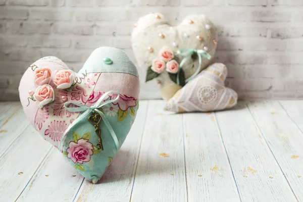 Tres corazones textiles con un romántico color de flores sobre un simple fondo de madera clara. enfoque selectivo. Hay un lugar para el texto . — Foto de Stock