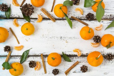 Noel kompozisyonu. Mandalina, köknar kozalave tarçın çubukları ile Noel çerçevesi,. Düz döşeme, üst görünüm.