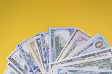 Abd Doları: Çeşitli Amerikan doları banknotlarının dağınık hayranı renkli arka planda iş kavramının en iyi görünümü.