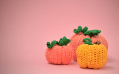 Sonbahar pembe arka plan örülmüş balkabaklarıyla. Farklı boyutlarda örülmüş balkabaklarının yan görünüşü. Sonbahar konsepti, metin için bir yer var..