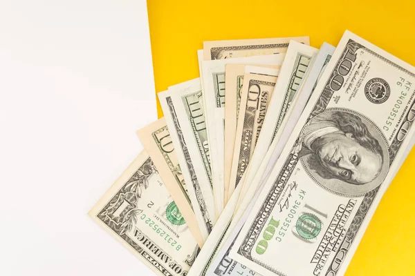 Abd Doları: Çeşitli Amerikan doları banknotlarının dağınık hayranı renkli arka planda iş kavramının en iyi görünümü.
