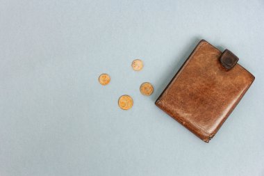 Gri arka planda dağınık avro paraları olan kahverengi cüzdan. Son para, yoksulluk, iş kaybı, tasarruf kavramı. Düz yat, kapat. Boşluğu kopyala