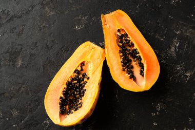 Siyah desenli arka planda taze ve lezzetli bir papaya kesimi. Boşluğun kopyası.