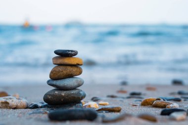 Çakıl taşları deniz kıyısındaki volkanik bir kayanın üzerine yığılır. Zen konsepti. Boşluğu kopyala.
