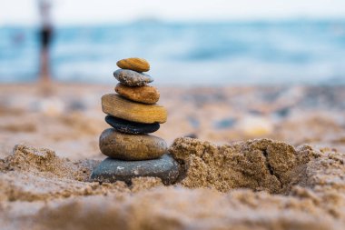 Çakıl taşları deniz kıyısındaki volkanik bir kayanın üzerine yığılır. Zen konsepti. Boşluğu kopyala.