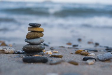 Çakıl taşları deniz kıyısındaki volkanik bir kayanın üzerine yığılır. Zen konsepti. Boşluğu kopyala.