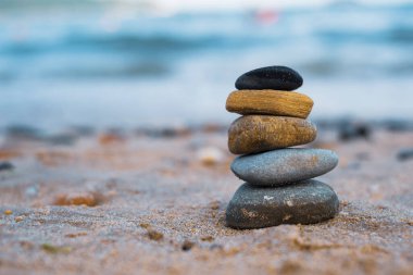 Çakıl taşları deniz kıyısındaki volkanik bir kayanın üzerine yığılır. Zen konsepti. Boşluğu kopyala.