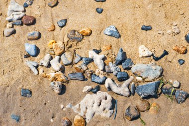 Renkli deniz taşları, doğal arka plan, doku. Renkli deniz taşlarının yakın çekim dokusu. Deniz arka planı ve plaj.
