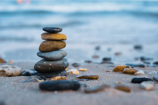 Pebbles are piled on a volcanic rock by the sea. Zen concept. Copy space.