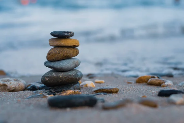 Pebbles are piled on a volcanic rock by the sea. Zen concept. Copy space.