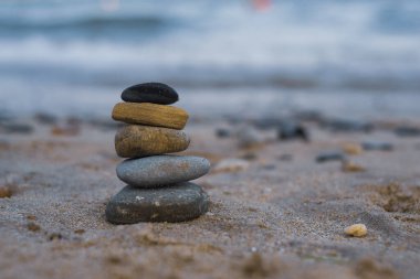 Çakıl taşları deniz kıyısındaki volkanik bir kayanın üzerine yığılır. Zen konsepti. Boşluğu kopyala.