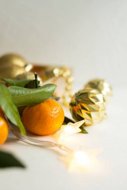 Bulanık mandalina ve altın topların arka planında turuncu mandalina. Işıltılı çelenklerle donuk, gümüşi bir arka planda kış kompozisyonu. Turuncu turunçgil meyvesi ve makro shot bırakır. Metin için bir yer var.
