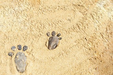 Çöl kumunun yüzeyinde iki çakıl taşı ayak izi. Kumsalda ve kumsalda oyunlar. Boşluğun bir kopyası.