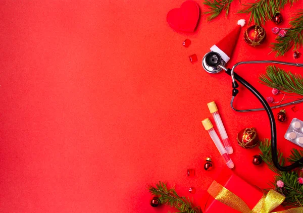 Christmas banner with a Phonendoscope wearing a Santa Claus hat. Nearby lie red balls, a heart, a gift box, branches of a Christmas tree, pills, and medical test tubes. Medical banner concept for New Year. flatly. The colors are red and gold.