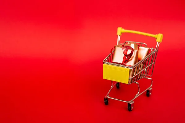 Lebensmittelkorb Mit Goldenen Geschenkboxen Mit Rotem Band Auf Rotem Hintergrund — Stockfoto