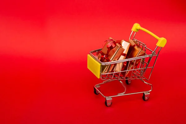 Lebensmittelkorb Mit Goldenen Geschenkboxen Mit Rotem Band Auf Rotem Hintergrund — Stockfoto