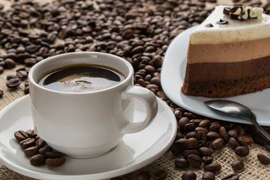 Kupası ve köpüklü cappuccino kahve fincan tabağı pastayla servis