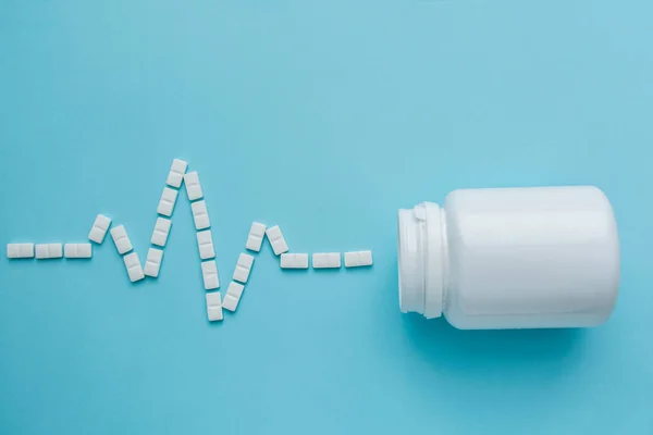 Gyógyszerek fehér, kerek szív alakú tabletták elszigetelt kék háttér. — Stock Fotó