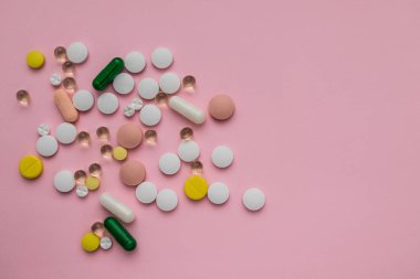 çok renkli hapları pembe bir arka plan üzerinde dağınık