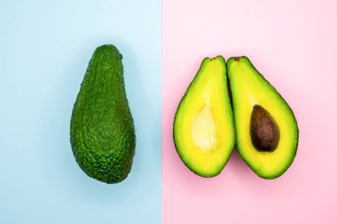 Avokado yarım mavi ve pembe arka plan en az gıda. Üstten Görünüm