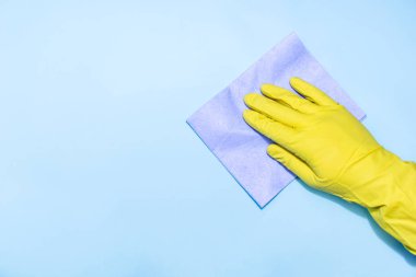 Mavi arka planda sünger ile eldiven adam el.