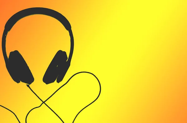 Black headphones isolated on yellow background. Selective focus of headphone.